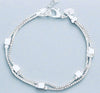Sterling silver charm bracelet made from recycled materials with elegant design.